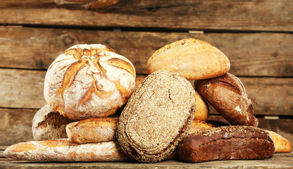 Different fresh bread on old wooden table