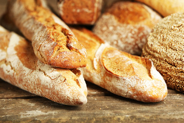 Different fresh bread on old wooden table