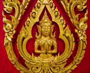 Fototapeta na wymiar Thai painting carved on a church's door. In the Thai Buddhist te