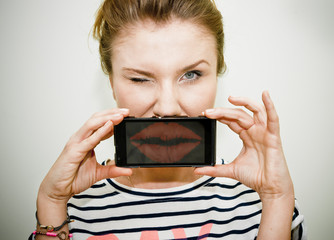 Woman sending kiss on smartphone