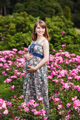 beautiful smiling pregnant woman. outdoor. against the