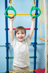 child hanging on gymnastic rings