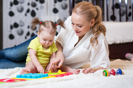 mom and kid playing block toys at home
