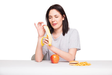 picture of woman with fruits and hamburger in front on white bac