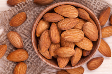 Almonds super food in a wooden dish on vintage textile backgroun