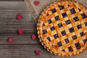 Raspberry pie with fresh raspberries and jam on vintage textile