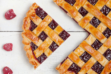 Sliced homemade raspberry pie closeup on white table. Top view