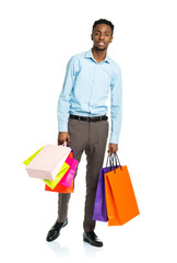 Happy african american man holding shopping bags on white backgr