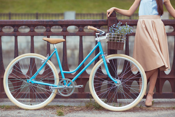 Young beautiful, elegantly dressed woman with bicycle