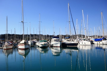 Fototapeta na wymiar Yachts and sail boats reflected in a Marina harbour