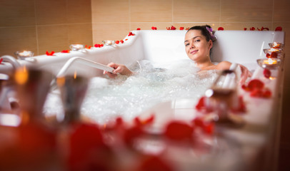 young beautiful brunette woman takes bubble bath