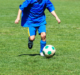 Young boy is running with a ball