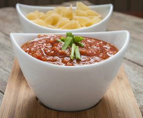 Tomato sauce and pasta on wooden background close up