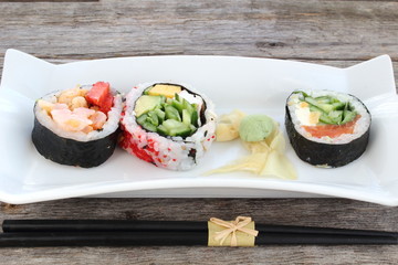 Sushi rolls entry on old wooden board