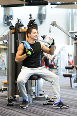 Fototapeta na wymiar smiling man exercising on gym machine
