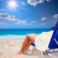 Fototapeta na wymiar Beautiful woman leg with sunhat on beach.