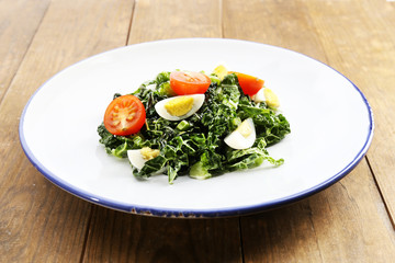 Salad with quail egg and basil in plate