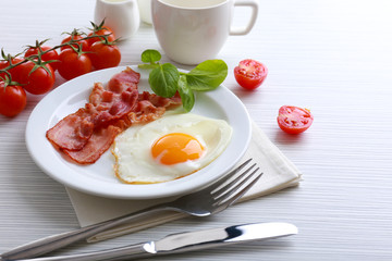 Bacon and eggs on color wooden table background