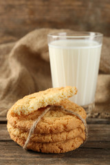 Tasty cookies and glass of milk on rustic wooden background