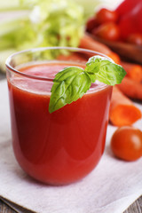 Glass of tomato juice with vegetables on wooden table close up