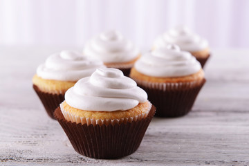 Delicious cupcakes on table on light background