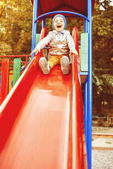 Little boy playing on children's slides