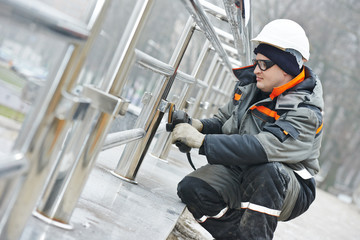 worker polishing metal fence barrier