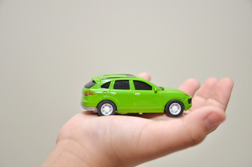 Green toy car on a right hand