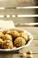 Tasty homemade pistachio candies on wooden table