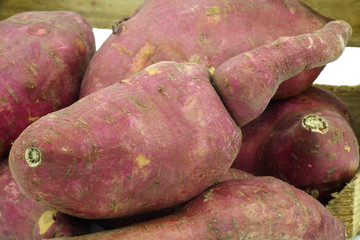sweet potatoes in a wooden crate on a white background
