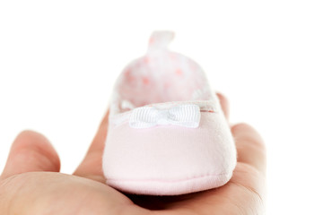 Close up pink baby shoes on hand