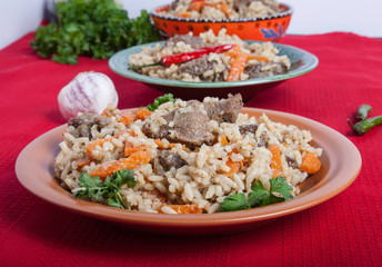 Three plates of hot delicious pilaf with garlic and parsley on r