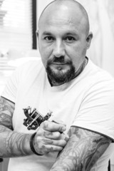 tattoo artist tattooing his arm.