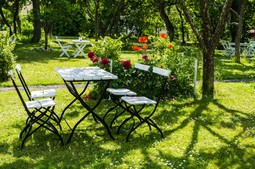 Garden furniture in a verdant park in Sweden. © annalovisa