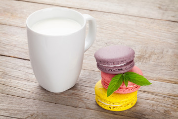Colorful macaron cookies and cup of milk