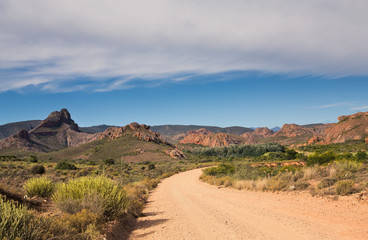 Dirt road leading over high mountain pass in daytime