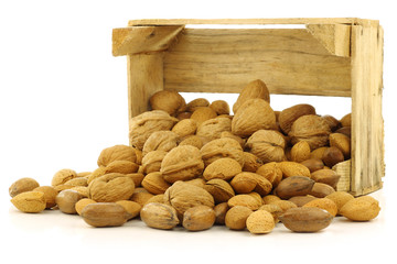 assorted nuts in a wooden box on a white background