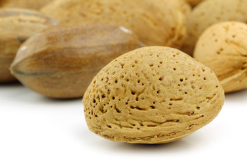 almond nut in front of mixed nuts on a white background
