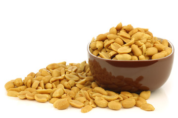 tasty peanuts in a brown bowl on a white background