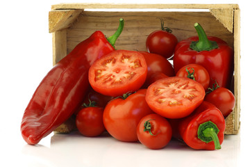 red sweet peppers and tomatoes in a wooden crate