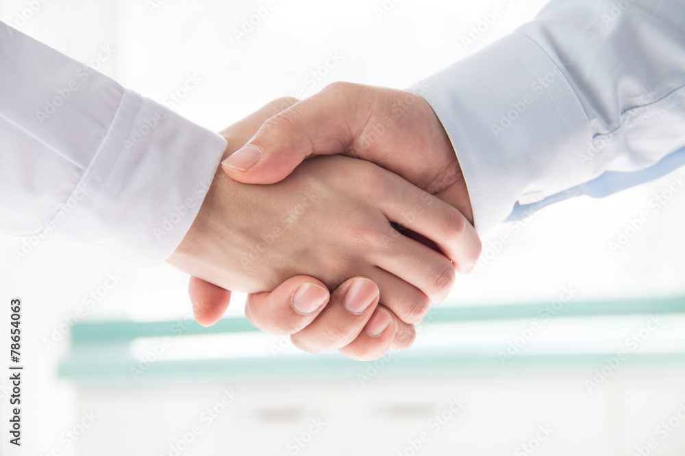 Wall mural Doctor and businessman shaking hands