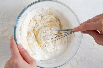 Corolla and broken eggs with flour mixing in bowl