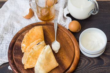 thin pancakes with cottage cheese, prunes, honey and sour cream