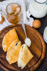 thin pancakes with cottage cheese, prunes, honey and sour cream