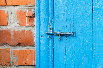 closed catch on old blue painted door of shed