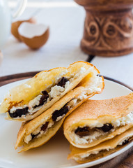 thin pancakes stuffed with cheese, prunes and sour cream, milk