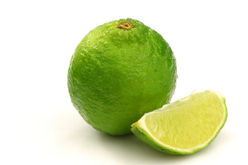 Fototapeta na wymiar one whole lime fruit and a piece on a white background