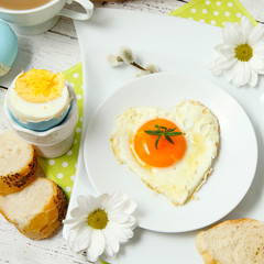 Easter table setting with flowers and eggs on old wooden table