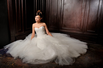 beautiful bride sitting posing in her wedding dress. Studio.