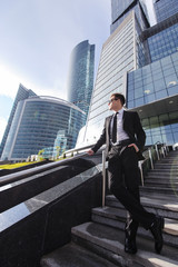 Businessman standing on the stairs of a business center and